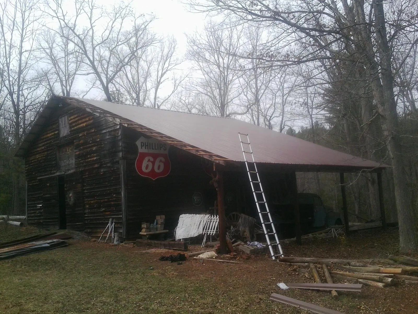 New metal roof on an open sided timber barn with a vintage sign in Browerville