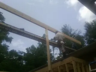 Carpenter setting a ridge beam over a new addition frame — Ice Dam Removal by Roofing Brothers in Browerville