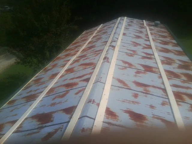 Rusted metal roof panels with new wood purlins before replacement — Storm Damage Roof Repair in Browerville by Roofing Brothers