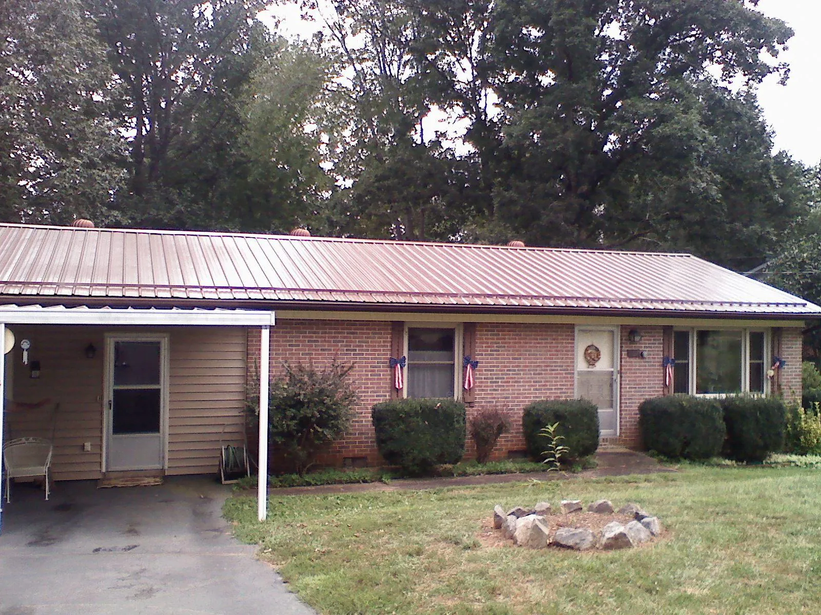 Bronze metal roof and carport on a brick ranch home — Roof Repair work by our crew in Browerville